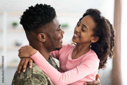 Cute black girl enjoying reunion with her father soldier