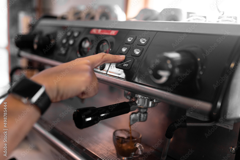 Unrecognizable barista pressing button on coffee machine Unrecognizable barista pressing button on coffee machine