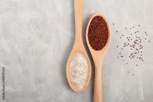 Coarse flour Ragi and red quinoa grain in wooden spoons on grey background. Gluten free healthy food photo