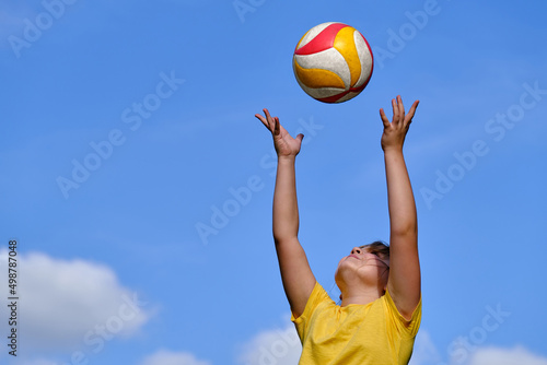 The girl plays volleyball. The child throws the ball with his hands. outdoor play.