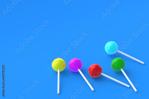 Colorful lollipops on stick on blue background. Sweet candy. Confectionery goods. Copy space. 3d render © OlekStock