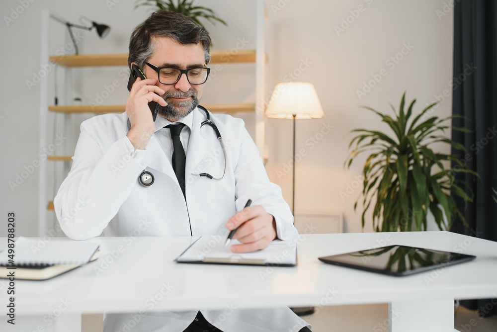 Portrait of senior doctor sitting in medical office. Portrait of senior doctor sitting in medical office.