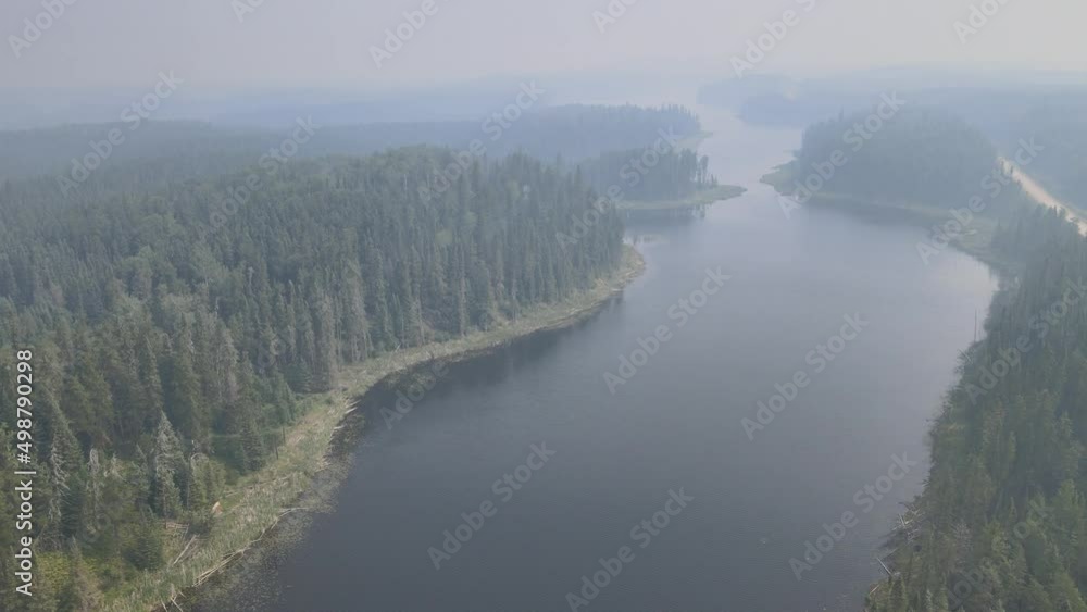 Drone moving forward above a silent looking lake and forest that are partly obscured by forest fire smoke. The lake has many small bays.
Drone moving forward above a silent looking lake and forest that are partly obscured by forest fire smoke. The lake has many small bays.