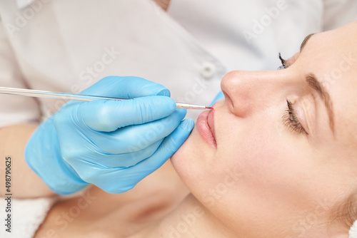 Permanent makeup. Beauty spa procedure. young woman. Face tattoo. Lip micropigmentation. Professional face microblading. Female cosmetology device. Copyspace. Mouth treatment. Dermatology