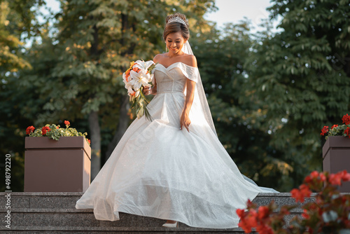 Bride gathering at the hotel. Bouquet of flowers and veil. Loving couple at an international wedding at sunset. Beautiful sophisticated bride of Asian appearance.