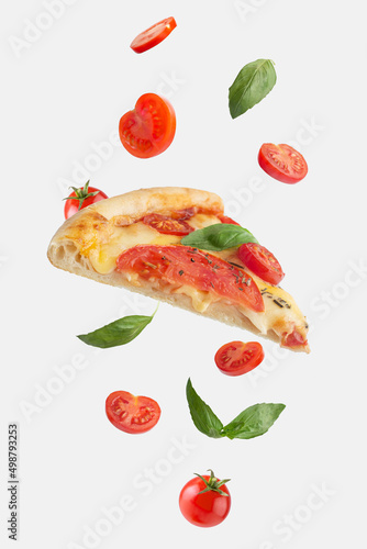 Fototapeta Naklejka Na Ścianę i Meble -  flying slice of margarita pizza with tomatoes and basil