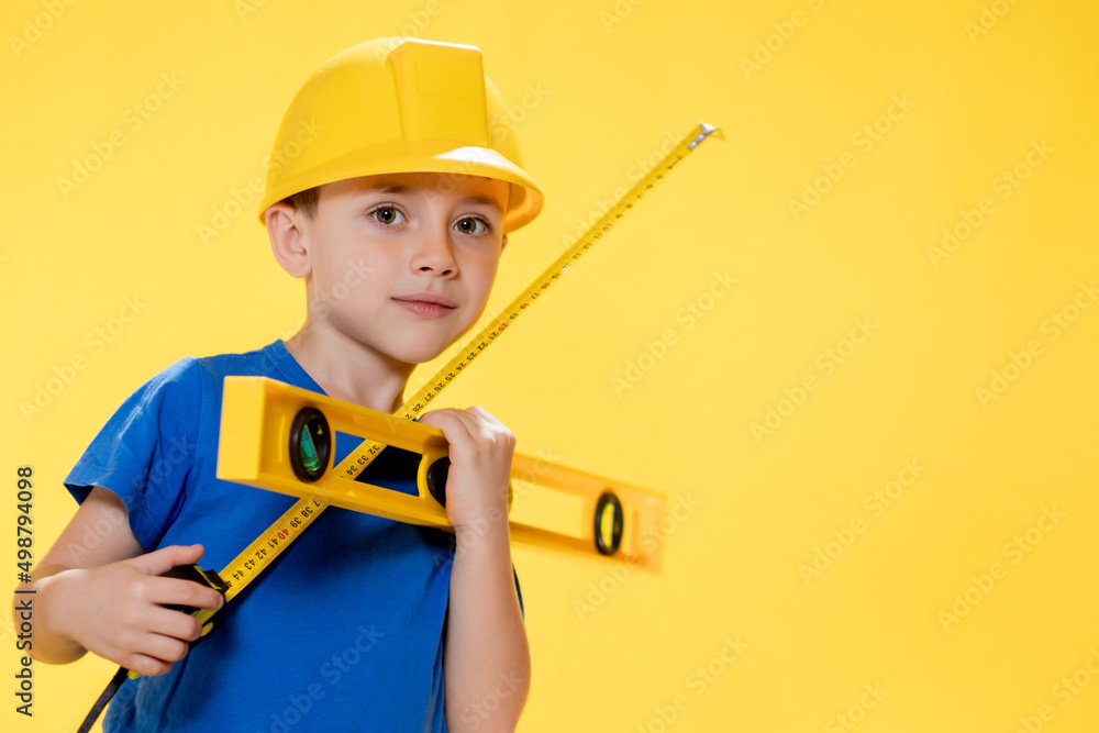 The preschooler in a helmet with a construction level plays a builder The preschooler in a helmet with a construction level plays a builder