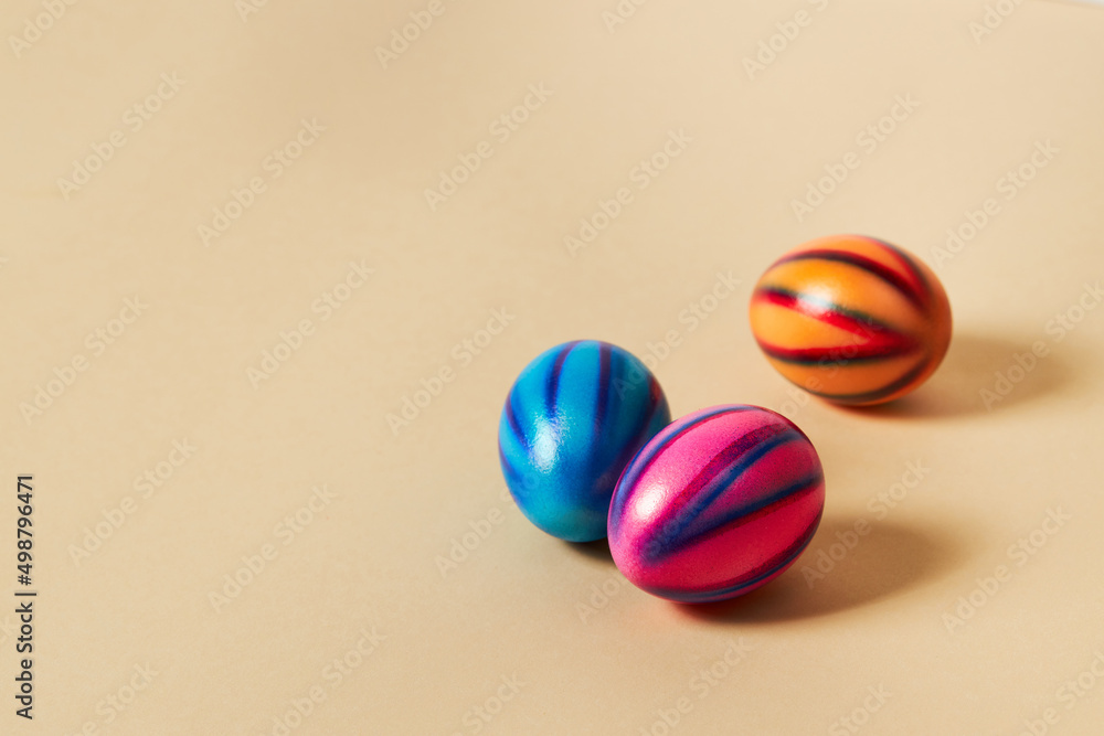 Obraz premium Colorful Easter eggs with on a solid beige background. Preparation for holiday.