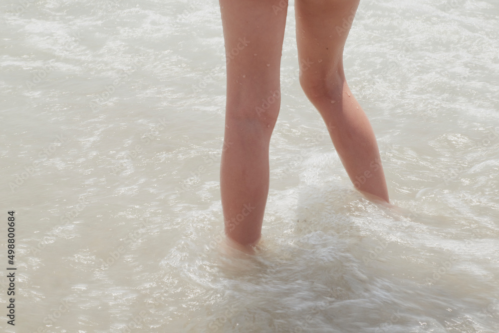 Girl's legs on the seashore during a sunny summer day, Spain