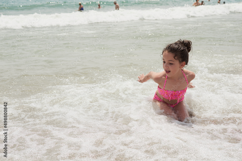 Girl playing happily on the shore of the beach, Vera, Spain Girl playing happily on the shore of the beach, Vera, Spain