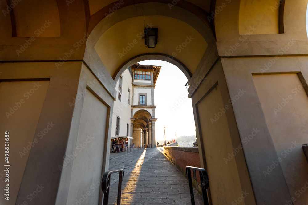 Morning view on beautiful arcade and riverside near famous Ponte Vecchio on Arno river in Florence, Italy. Concept of italian renaissance architecture and cityscape