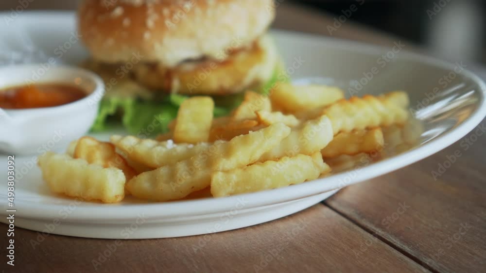 Vegetarian burger with red sauce and fries standing on a white plate Vegetarian burger with red sauce and fries standing on a white plate