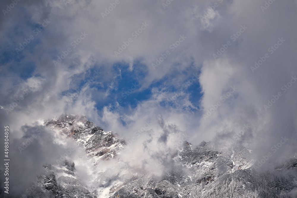 Very cloudy sky over mountains covered with snow near the alps