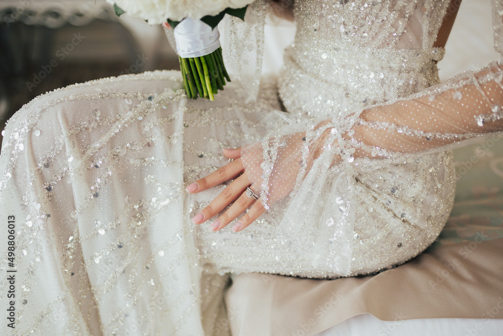 Close up of luxury wedding dress of bride. Rings on the finger. Close up of luxury wedding dress of bride. Rings on the finger.