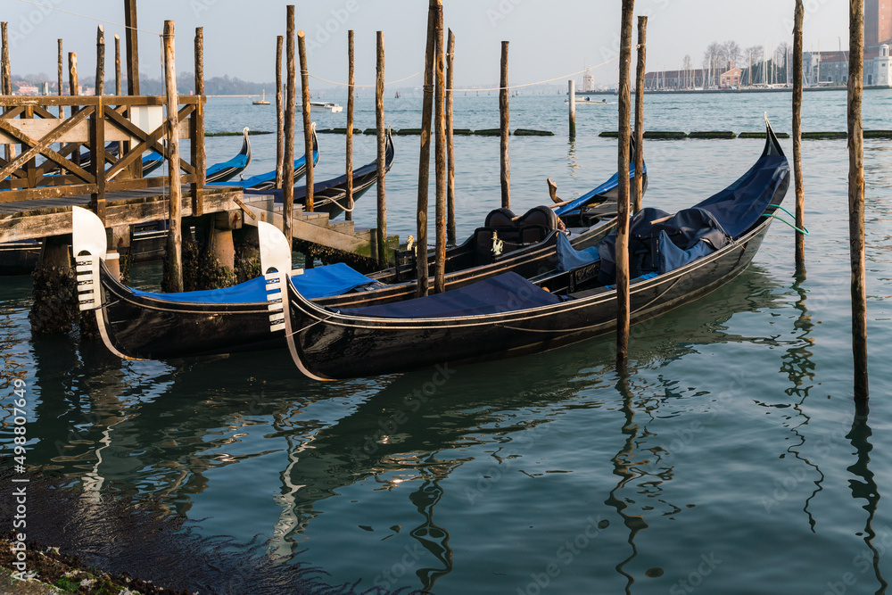 gondolas parked by the grand canal in Venice, Italy with the church of Saint Giorgio Maggiore in the background