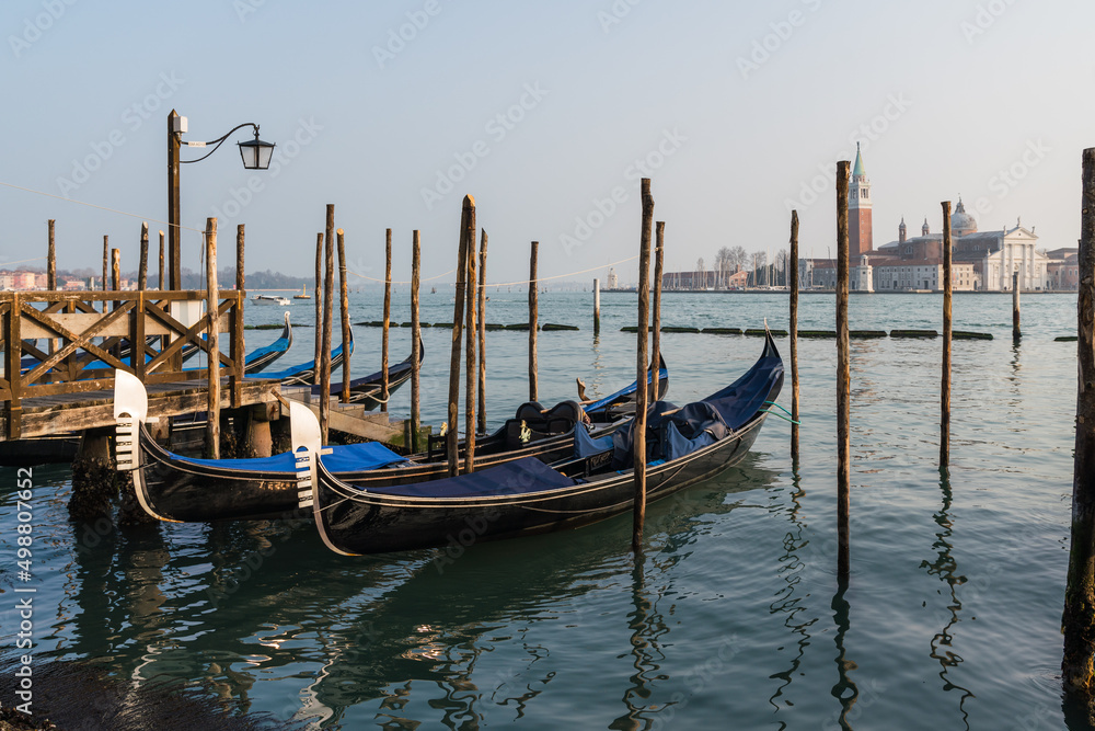 gondolas parked by the grand canal in Venice, Italy with the church of Saint Giorgio Maggiore in the background