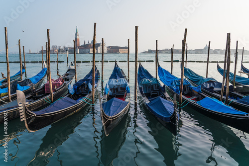 gondolas parked by the grand canal in Venice, Italy with the church of Saint Giorgio Maggiore in the background © gammaphotostudio