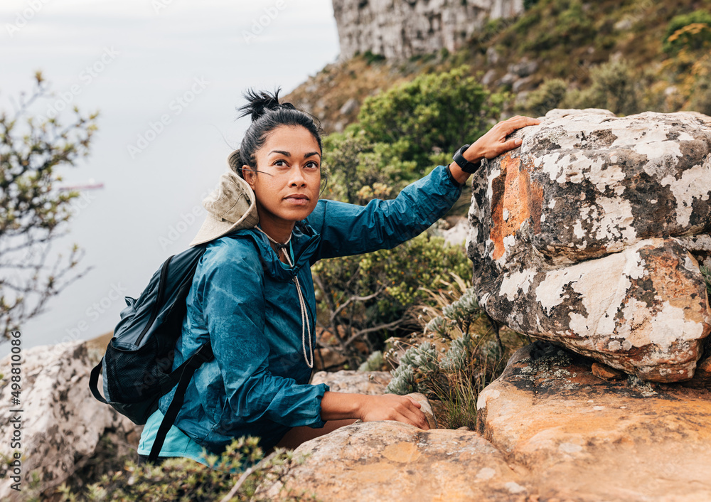 Woman in sportswear with backpack climbing up in wild terrain Woman in sportswear with backpack climbing up in wild terrain
