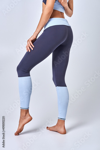 A young girl in blue sweatpants on a white background