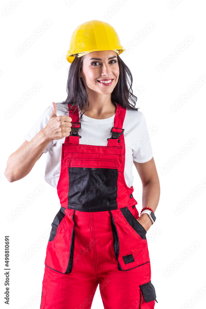 Glamorous brunette wearing contruction workers clothes and yellow helmet. Also doing a thumb up sign. Isolated background Glamorous brunette wearing contruction workers clothes and yellow helmet. Also doing a thumb up sign. Isolated background