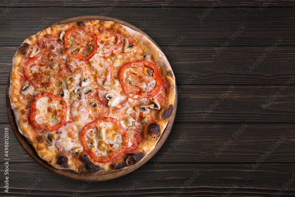 Pizza with mushrooms and tomatoes, on a round wooden board