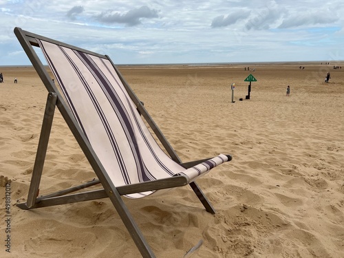 Fotobehang Landscape Deckchair on sandy beach  with windy breeze on beautiful Wells Next th