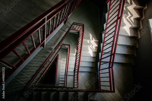 Canvas Staircase with red railings descending in a spiral