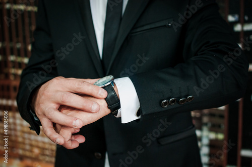 Wristwatch on a man's hand. Watch on the hand of a man in a black jacket
