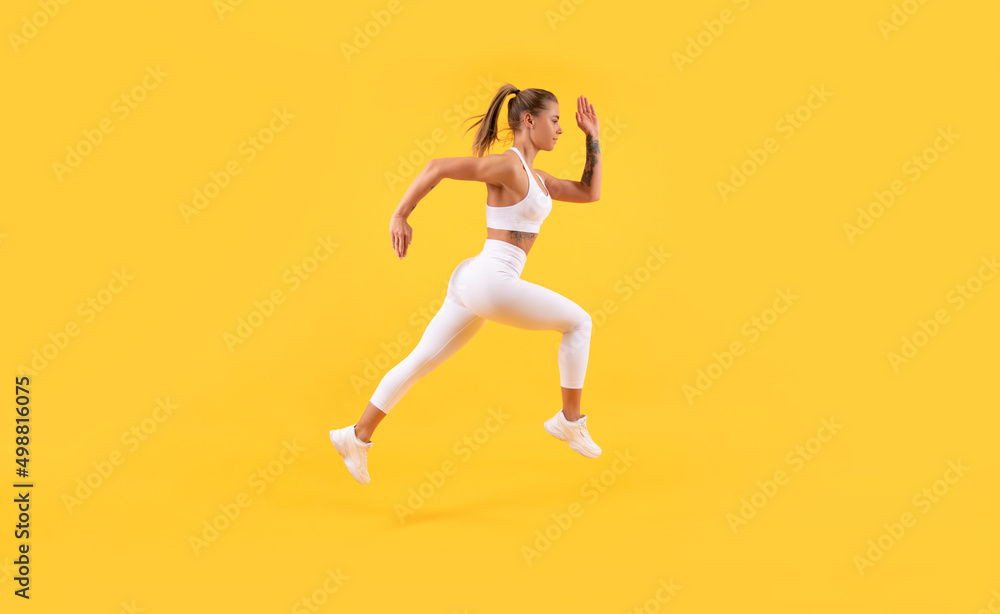 energetic fitness woman runner running on yellow background