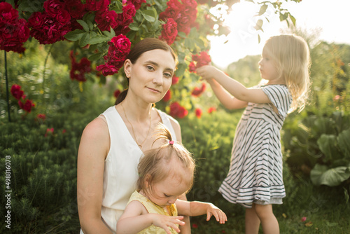 Obraz na płótnie mother hugs her daughter, relax, collect a bouquet of roses w salonie
