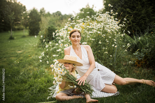 Obraz na płótnie mother plays with her daughter, relax, collect daisies w salonie