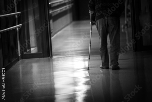 Man with a cane walking in a hallway of a retirement home.