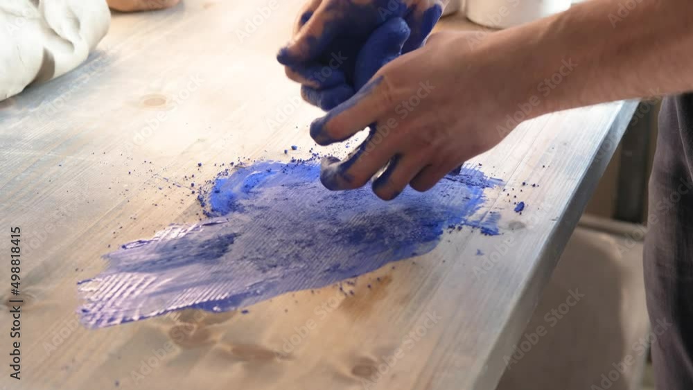 Close up of male hands working on blue clay in an atelier Close up of male hands working on blue clay in an atelier