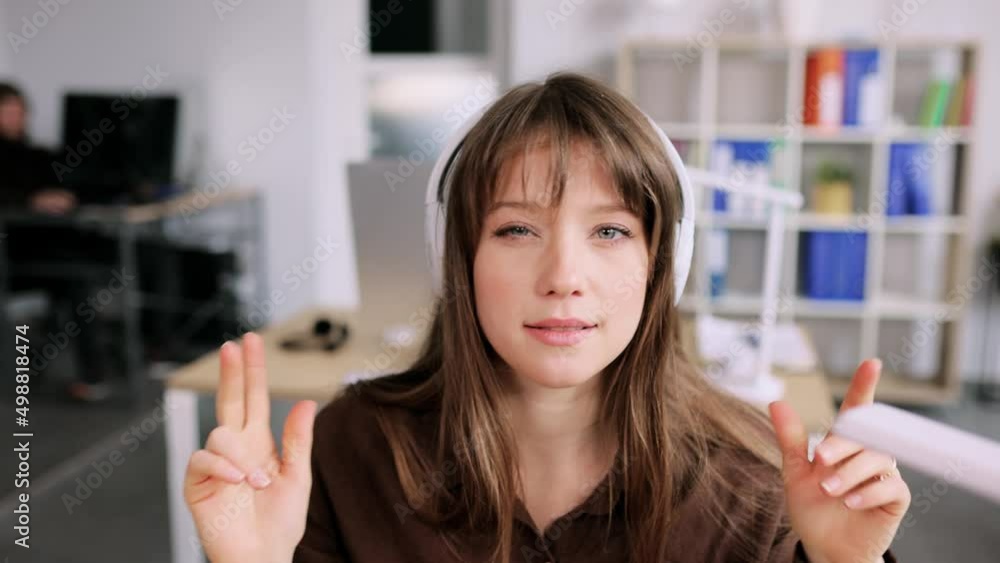 Young attractive woman have a video call while sitting on the chair in the office. Young lady talking on video conference online indoors. High quality 4k footage Young attractive woman have a video call while sitting on the chair in the office. Young lady talking on video conference online indoors. High quality 4k footage