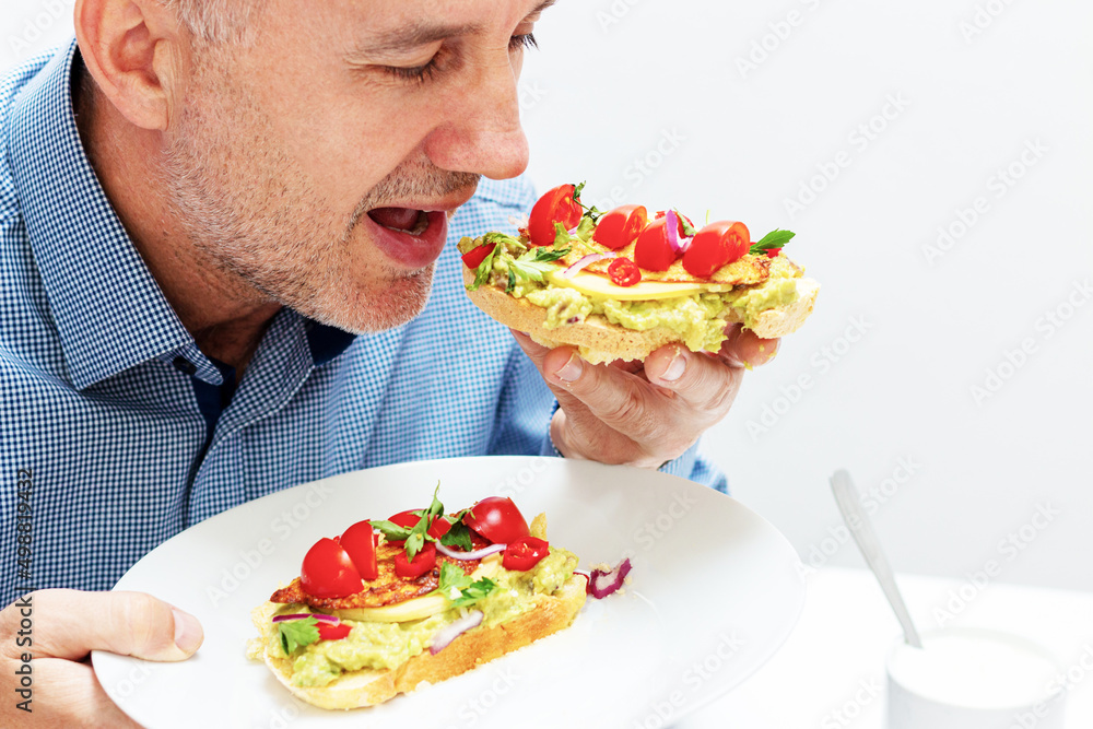 Healthy open vegan sandwich with avocado mash, zucchini, cherry tomatoes, cheese on top of corn bread. Healthy food, vegetarian food concept Healthy open vegan sandwich with avocado mash, zucchini, cherry tomatoes, cheese on top of corn bread. Healthy food, vegetarian food concept