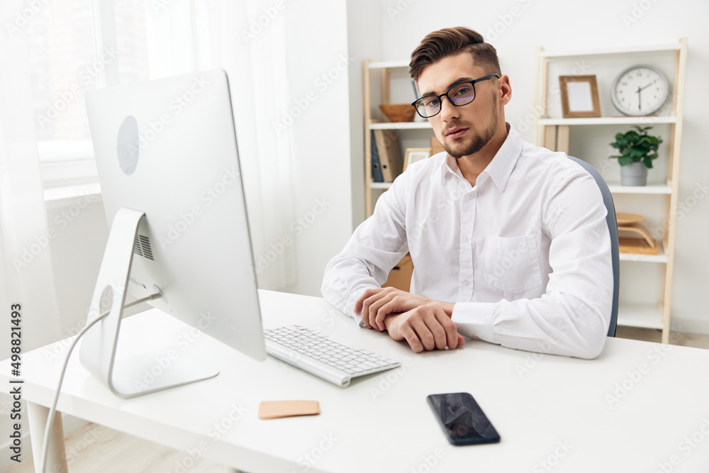 manager sitting at a desk in front of a computer with a keyboard executive manager sitting at a desk in front of a computer with a keyboard executive