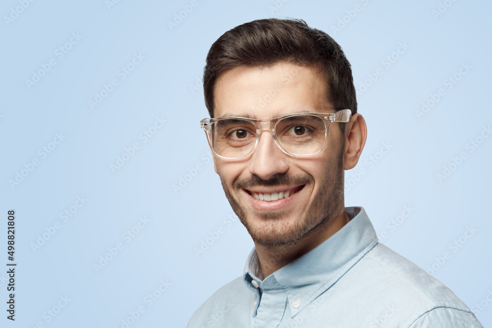 Young attractive European man with short haircut looks at camera with happy smile