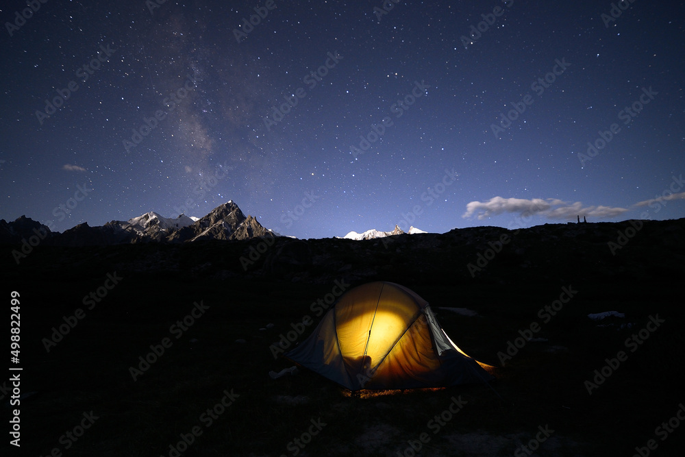A faint Milkyway galaxy and lit up a camp of trekkers on the brink of Biafo glacier, Karakoram Range, Pakistan. 