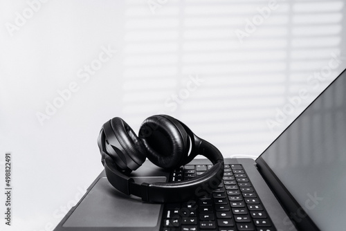 Fotografia Modern wireless headphones over the laptop computer while taking break