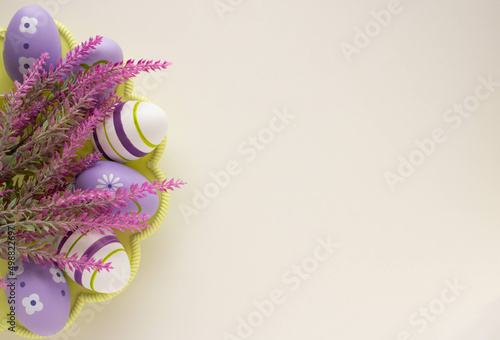 Easter concept lilac Easter eggs with a branch of artificial lavender on a light background. Place for your text