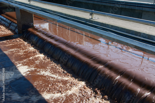 Obraz na płótnie Weir of a wastewater treatment plant with overflowing activated sludge