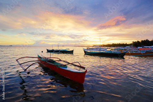 Fototapeta Naklejka Na Ścianę i Meble -  Beautiful colorful sunset on the seashore with fishing boats. Philippines, Siargao Island.