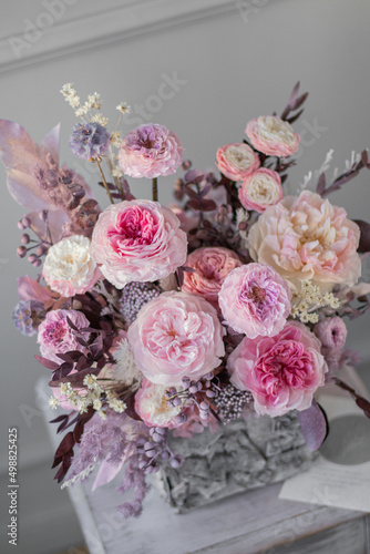 Flowers arrangement with roses in bark pot in vintage.