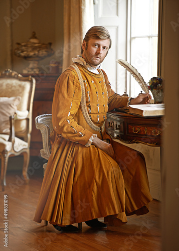 I have urgent correspondence for the the king. Shot of an aristocratic man at his writing table. photo