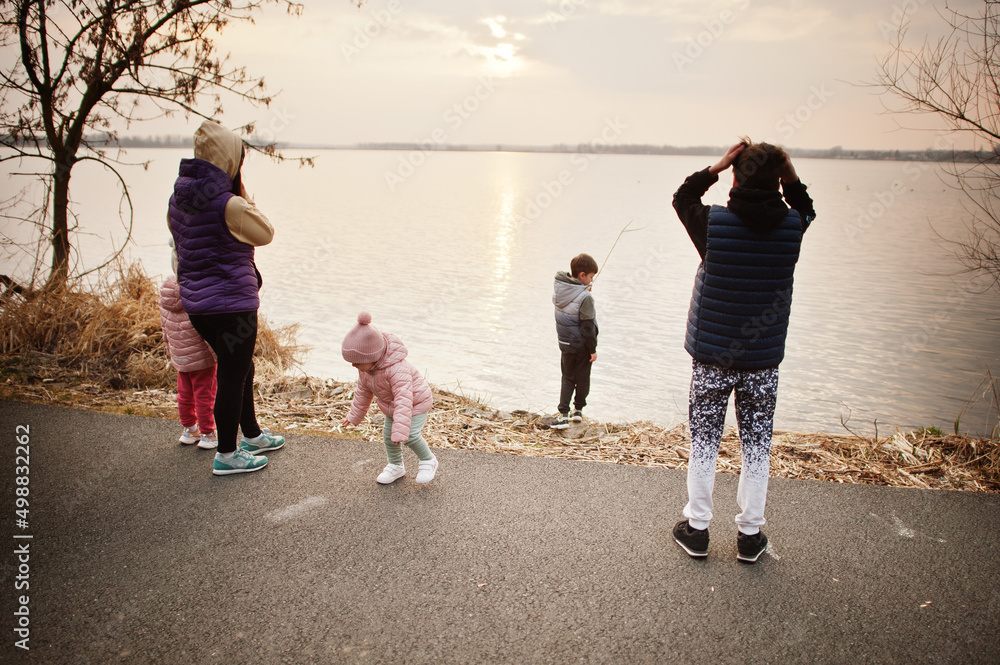 Obraz premium Mother with kids on the shore of the lake.