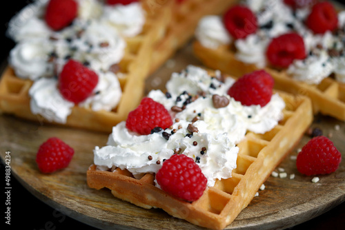 Soft focus. Macro. French waffles with cream and fresh raspberries.
