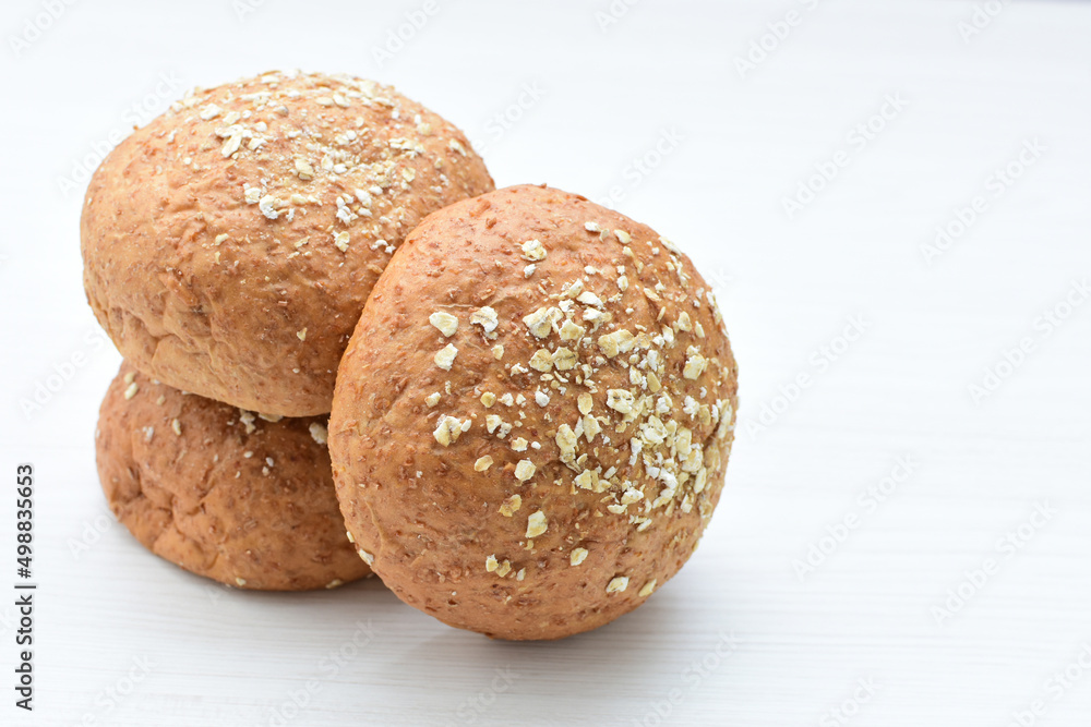Round wholemeal oat bread, sweetened with natural panela, displayed on white wood Round wholemeal oat bread, sweetened with natural panela, displayed on white wood