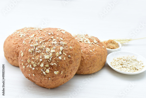 Konstfotografi Round wholemeal oat bread, sweetened with natural panela, displayed on white woo