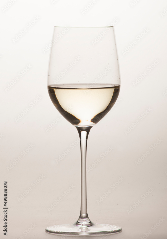 white wine in a special glass for white wine close-up in the studio on a light background without people