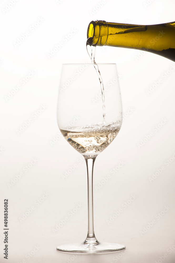 white wine is poured into a special glass on a light background in the studio close-up without a person white wine is poured into a special glass on a light background in the studio close-up without a person